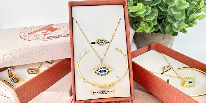 Evil Eye gift sets stacked on top of each other with a plant.